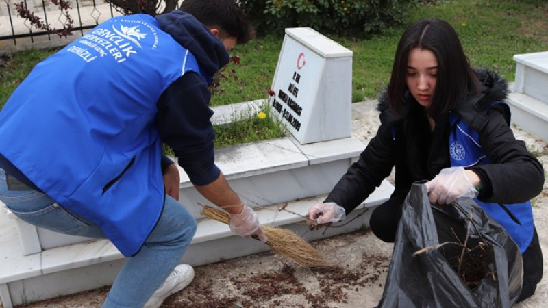 GÖNÜLLÜ GENÇLER ŞEHİT MEZARLIĞINDA TEMİZLİK YAPTI